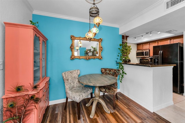 704 Lyndhurst St Unit 624, Dunedin, FL 34698 - dining space featuring baseboards, wood finished floors, and ornamental molding