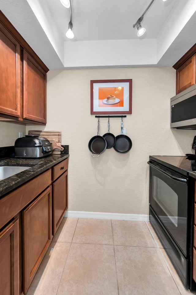 704 Lyndhurst St Unit 624, Dunedin, FL 34698 - kitchen featuring black electric range oven, stainless steel microwave, rail lighting, and baseboards