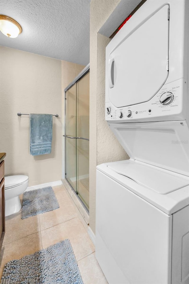 704 Lyndhurst St Unit 624, Dunedin, FL 34698 - laundry area featuring estacked washer and dryer, a textured ceiling, and light tile patterned floors