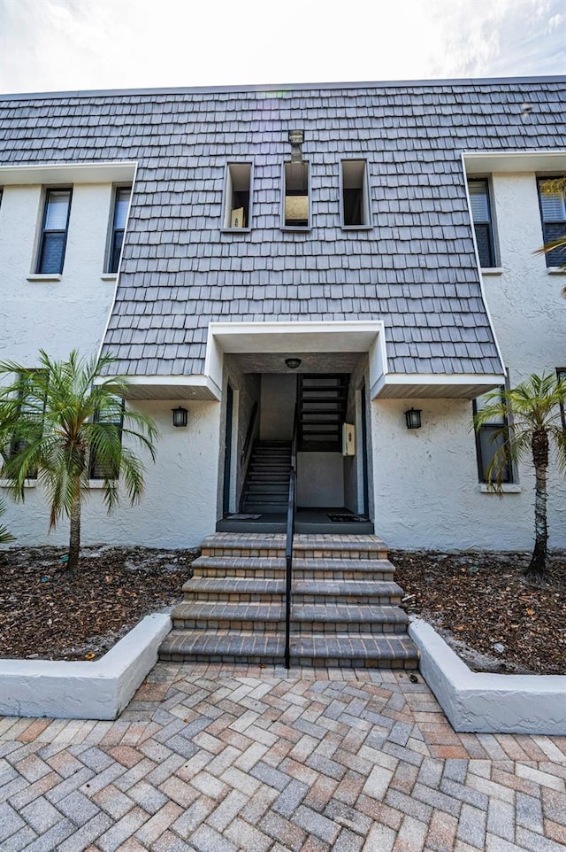704 Lyndhurst St Unit 624, Dunedin, FL 34698 - view of exterior entry featuring stucco siding and mansard roof