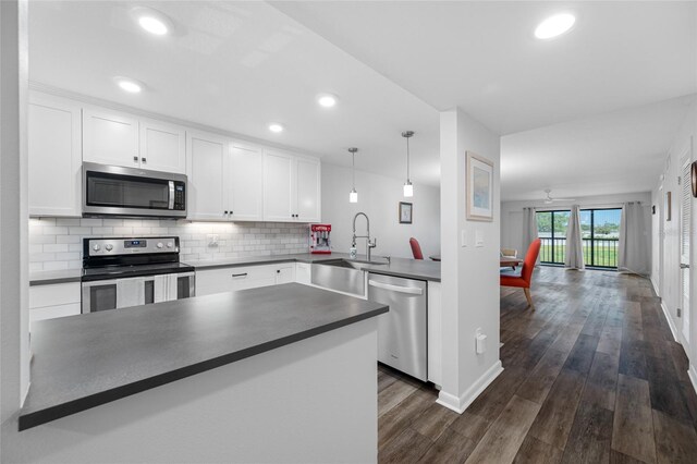 9450 Harbor Greens Way Unit 207, Seminole, FL 33776 - kitchen featuring appliances with stainless steel finishes, dark countertops, a sink, tasteful backsplash, and white cabinets