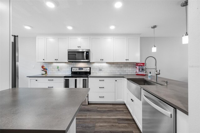 9450 Harbor Greens Way Unit 207, Seminole, FL 33776 - kitchen with stainless steel appliances, a sink, dark countertops, backsplash, and recessed lighting