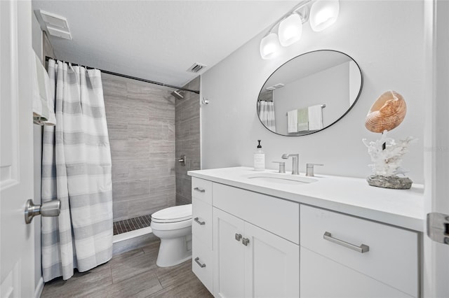 9450 Harbor Greens Way Unit 207, Seminole, FL 33776 - bathroom featuring vanity, toilet, tiled shower, and wood finished floors