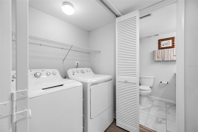 9450 Harbor Greens Way Unit 207, Seminole, FL 33776 - laundry area featuring washing machine and clothes dryer, dark marble finish flooring, and baseboards