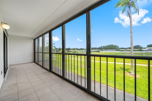 9450 Harbor Greens Way Unit 207, Seminole, FL 33776 - unfurnished sunroom featuring a water view, tile patterned flooring, and plenty of natural light