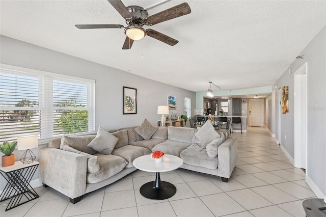 14401 Gulf Blvd Unit 106, Madeira Beach, FL 33708 - living room with a textured ceiling, light tile patterned floors, ceiling fan, and baseboards