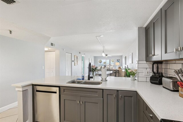 14401 Gulf Blvd Unit 106, Madeira Beach, FL 33708 - kitchen with a sink, a peninsula, gray cabinets, light countertops, and open floor plan