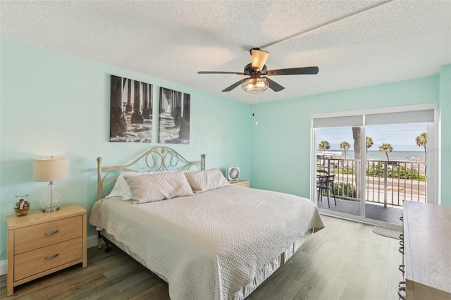 14401 Gulf Blvd Unit 106, Madeira Beach, FL 33708 - bedroom with access to exterior, wood finished floors, a textured ceiling, and a ceiling fan
