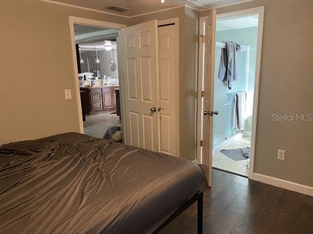 3512 16th St E, Bradenton, FL 34208 - bedroom with wood finished floors, connected bathroom, baseboards, a sink, and a closet