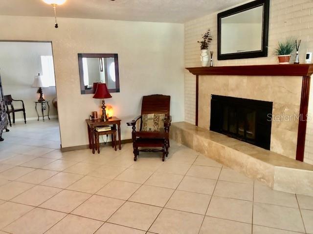 14530 Apache Ave, Largo, FL 33774 - living area with baseboards, a premium fireplace, and tile patterned flooring