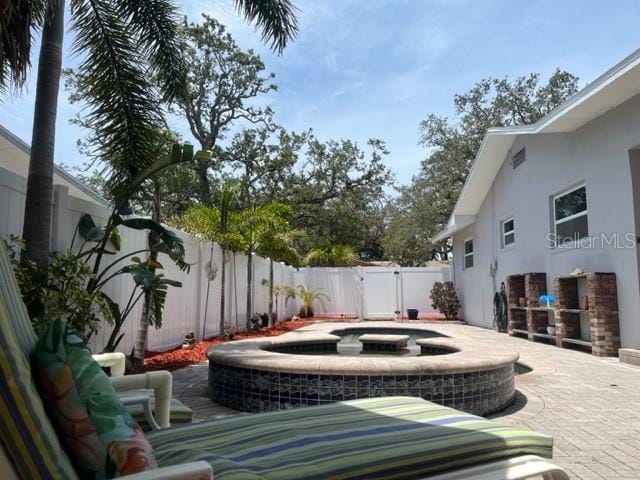 14530 Apache Ave, Largo, FL 33774 - fenced backyard with a pool with connected hot tub, a patio, and a gate