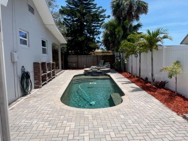 14530 Apache Ave, Largo, FL 33774 - view of swimming pool featuring a fenced backyard, a patio, and a pool with connected hot tub