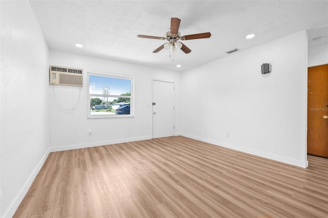 5326 22nd Ave N, Saint Petersburg, FL 33710 - unfurnished room featuring a wall mounted AC, ceiling fan, light wood-type flooring, a textured ceiling, and baseboards