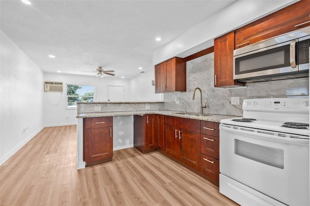 5326 22nd Ave N, Saint Petersburg, FL 33710 - kitchen with electric range, stainless steel microwave, a sink, a peninsula, and light wood-type flooring