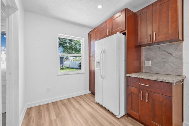 5326 22nd Ave N, Saint Petersburg, FL 33710 - kitchen with white refrigerator with ice dispenser, light wood finished floors, tasteful backsplash, light stone counters, and recessed lighting