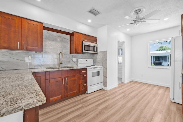 5326 22nd Ave N, Saint Petersburg, FL 33710 - kitchen with white appliances, a sink, a ceiling fan, light wood-style flooring, and decorative backsplash