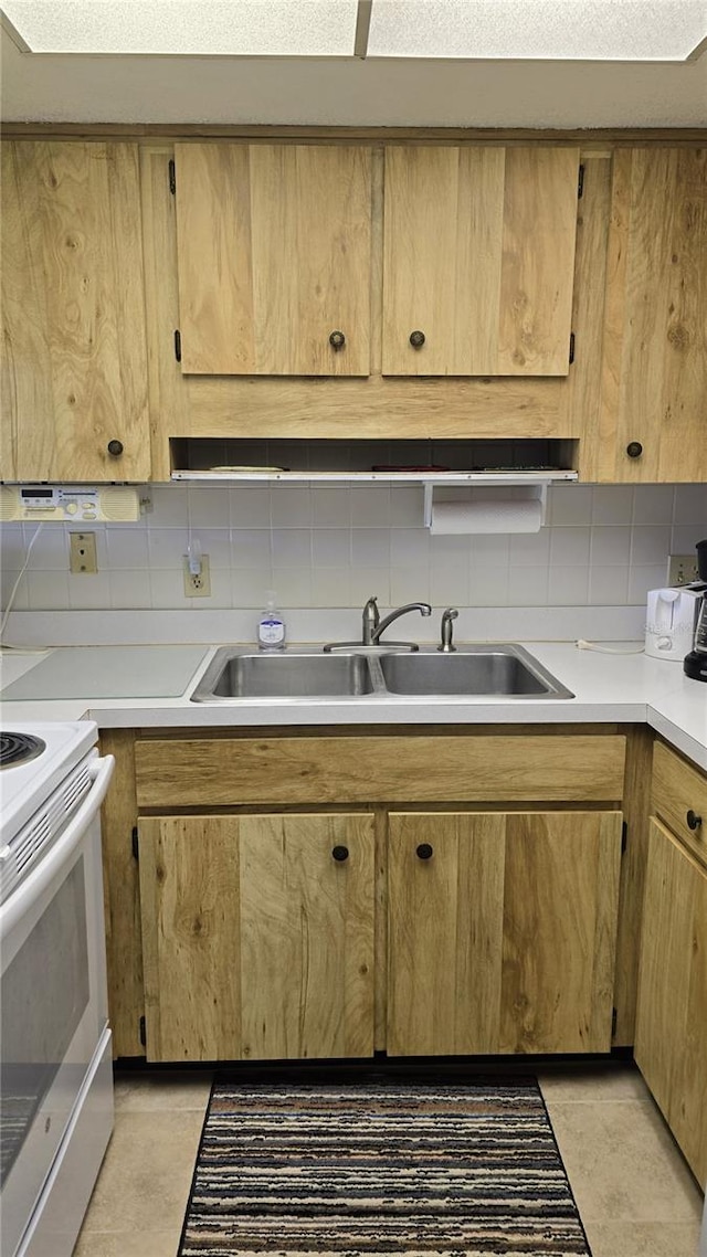 4324 Tahitian Gardens Cir Unit J, Holiday, FL 34691 - kitchen with white range with electric stovetop, a sink, light countertops, and backsplash