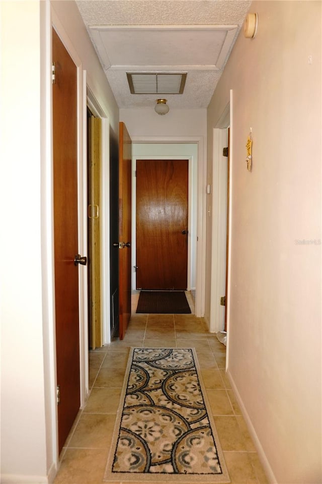 4324 Tahitian Gardens Cir Unit J, Holiday, FL 34691 - corridor featuring attic access and light tile patterned floors