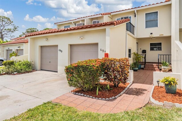 2700 Bayshore Blvd Unit 497, Dunedin, FL 34698 - mediterranean / spanish house with driveway, stucco siding, a garage, and a tiled roof