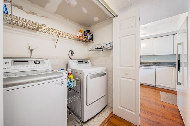 2700 Bayshore Blvd Unit 497, Dunedin, FL 34698 - laundry room with separate washer and dryer, tile walls, and light wood-style floors