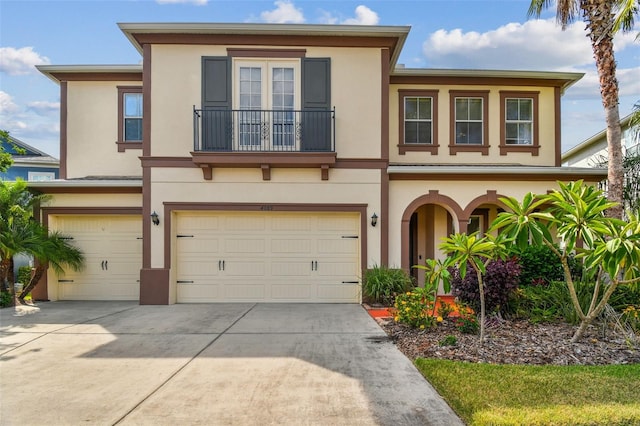 4089 Windcrest Dr, Wesley Chapel, FL 33544 - townhome / multi-family property featuring an attached garage, stucco siding, a balcony, and driveway
