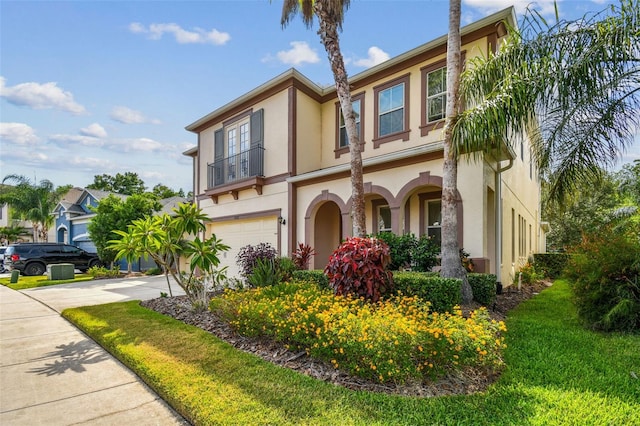 4089 Windcrest Dr, Wesley Chapel, FL 33544 - view of front of house featuring a garage, concrete driveway, stucco siding, and a balcony