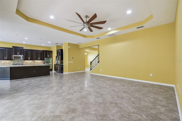 4089 Windcrest Dr, Wesley Chapel, FL 33544 - unfurnished living room with a raised ceiling, a ceiling fan, stairs, recessed lighting, and baseboards