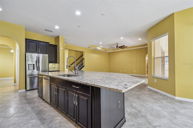 4089 Windcrest Dr, Wesley Chapel, FL 33544 - kitchen with arched walkways, appliances with stainless steel finishes, a sink, ceiling fan, and a kitchen island with sink