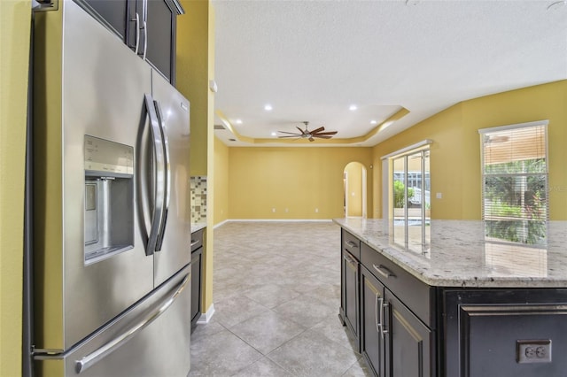 4089 Windcrest Dr, Wesley Chapel, FL 33544 - kitchen with stainless steel refrigerator with ice dispenser, arched walkways, recessed lighting, light stone counters, and a ceiling fan