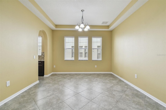 4089 Windcrest Dr, Wesley Chapel, FL 33544 - unfurnished room featuring a chandelier, arched walkways, a tray ceiling, and light tile patterned flooring