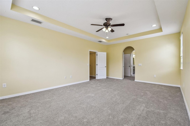 4089 Windcrest Dr, Wesley Chapel, FL 33544 - unfurnished bedroom featuring a tray ceiling, carpet floors, arched walkways, baseboards, and recessed lighting