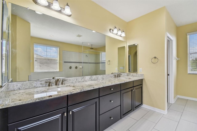 4089 Windcrest Dr, Wesley Chapel, FL 33544 - full bathroom with tiled shower, double vanity, baseboards, and tile patterned floors