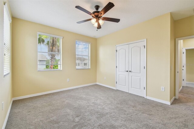 4089 Windcrest Dr, Wesley Chapel, FL 33544 - unfurnished bedroom featuring carpet, a closet, baseboards, and a ceiling fan