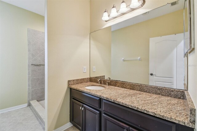 4089 Windcrest Dr, Wesley Chapel, FL 33544 - bathroom featuring vanity, a tile shower, baseboards, and tile patterned floors