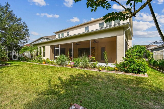 4089 Windcrest Dr, Wesley Chapel, FL 33544 - rear view of property featuring a ceiling fan, stucco siding, and a lawn