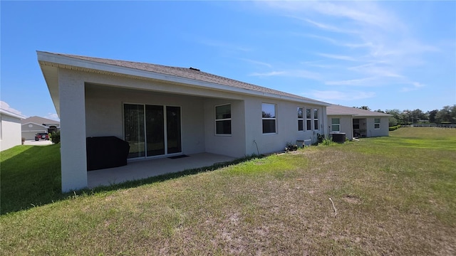 13111 Pepper Stem St, Spring Hill, FL 34609 - back of property featuring stucco siding, central air condition unit, a patio, and a lawn