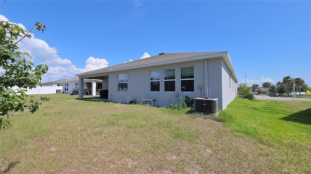 13111 Pepper Stem St, Spring Hill, FL 34609 - rear view of house with central air condition unit, stucco siding, and a yard
