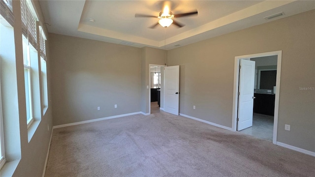 13111 Pepper Stem St, Spring Hill, FL 34609 - unfurnished bedroom with a tray ceiling, light colored carpet, baseboards, and ceiling fan