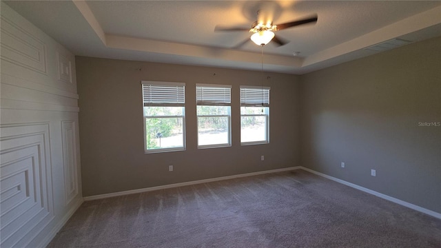 13111 Pepper Stem St, Spring Hill, FL 34609 - spare room with a tray ceiling, carpet floors, ceiling fan, and baseboards