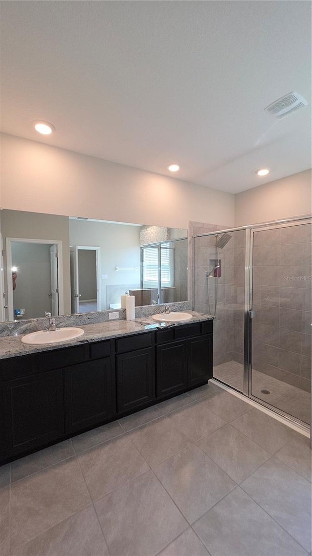 13111 Pepper Stem St, Spring Hill, FL 34609 - bathroom with double vanity, a stall shower, tile patterned floors, and recessed lighting