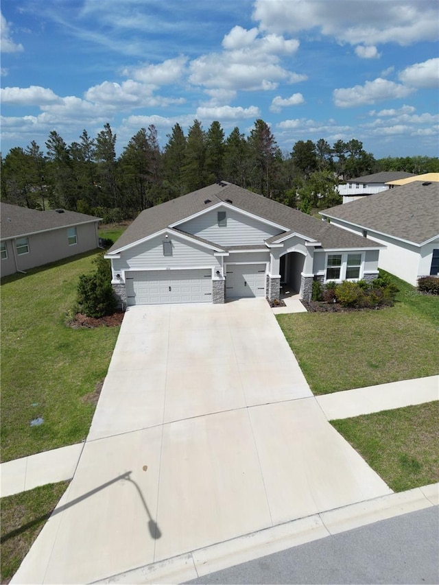 13111 Pepper Stem St, Spring Hill, FL 34609 - single story home featuring an attached garage, a front yard, driveway, and stone siding