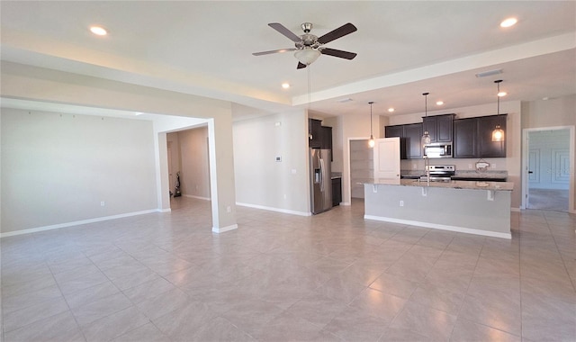 13111 Pepper Stem St, Spring Hill, FL 34609 - unfurnished living room with recessed lighting, ceiling fan, baseboards, and a tray ceiling