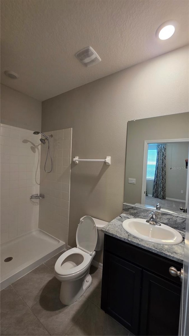 13111 Pepper Stem St, Spring Hill, FL 34609 - bathroom with tiled shower, toilet, vanity, tile patterned floors, and a textured ceiling