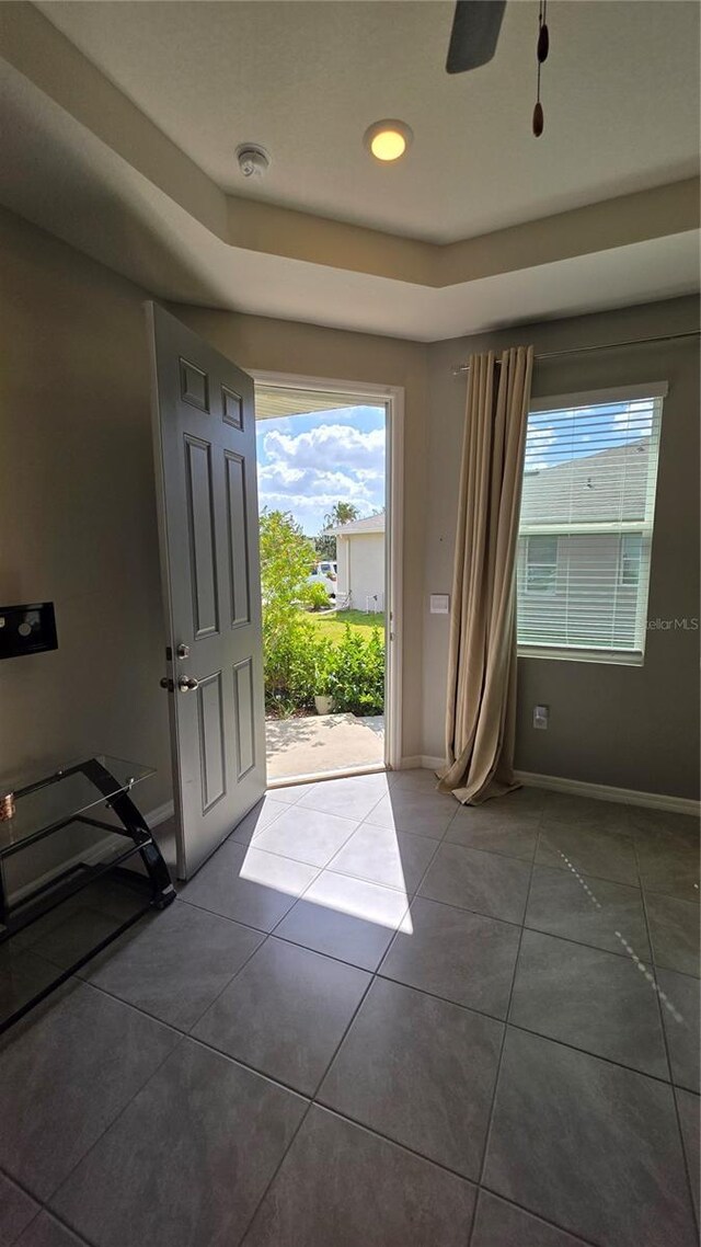 13111 Pepper Stem St, Spring Hill, FL 34609 - foyer featuring a tray ceiling, baseboards, plenty of natural light, and tile patterned floors
