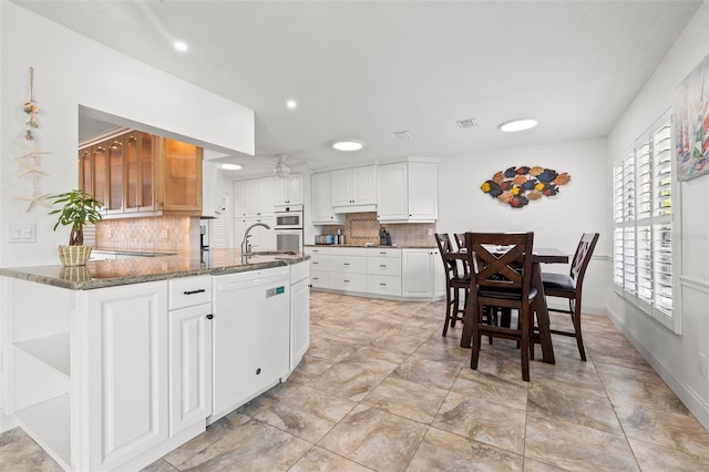 629 Fort Duquesna Dr, Sun City Center, FL 33573 - kitchen featuring white appliances, decorative backsplash, a sink, open shelves, and dark stone countertops