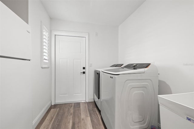 629 Fort Duquesna Dr, Sun City Center, FL 33573 - washroom featuring wood finished floors, washing machine and clothes dryer, and baseboards