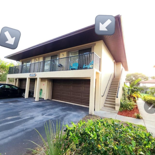 2935 Lichen Ln Unit D, Clearwater, FL 33760 - view of property with stucco siding, a garage, stairway, and driveway