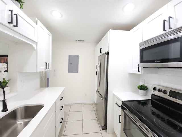 2935 Lichen Ln Unit D, Clearwater, FL 33760 - kitchen with stainless steel appliances, electric panel, white cabinets, light countertops, and recessed lighting