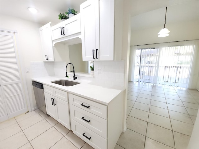 2935 Lichen Ln Unit D, Clearwater, FL 33760 - kitchen with stainless steel dishwasher, light tile patterned floors, tasteful backsplash, and white cabinetry