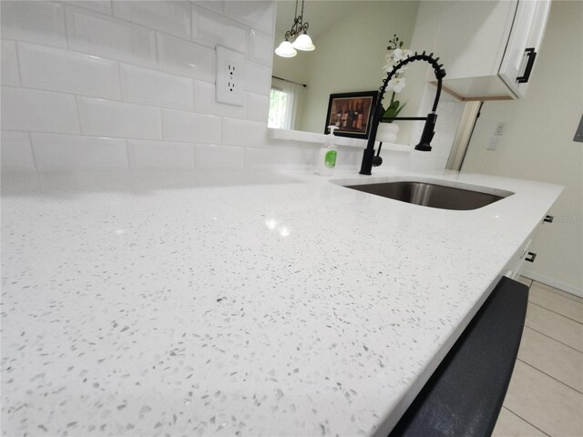 2935 Lichen Ln Unit D, Clearwater, FL 33760 - kitchen view of white cabinetry, light stone countertops, pendant lighting, and dishwashing machine